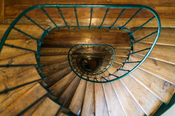 Beautiful design of wooden spiral stairway with green metal balustrade