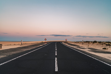 Fototapeta premium Beautiful road in the desert of Fuerteventura, Canary Islands at sunset