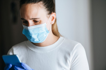 Young woman with face mask using mobile phone, close portrait