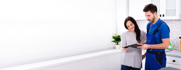 Male Plumber Showing Invoice To Woman