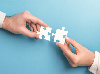 People holds in hand a jigsaw puzzle. Business solutions, success and strategy. - obrazy, fototapety, plakaty