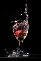 Copa con agua o alcohol y frutilla