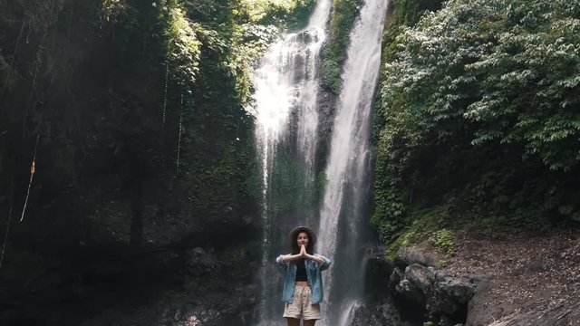 tourist girl on the background of a waterfall in Bali