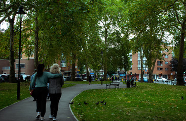 Friends walk in a park in London, UK