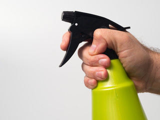 one hand holding a green spray can