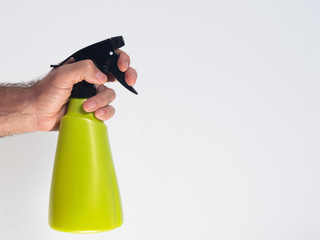 one hand holding a green spray can