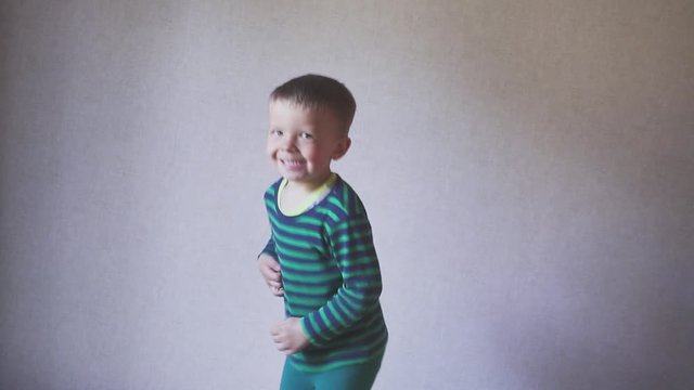 Happy fany boy child jumping on bed in bedroom. Childhood concept. skow motion.