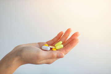 A Handful Of Colored Pills On A Female Hand