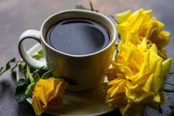 Cup of coffee and yellow roses