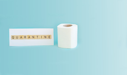 The inscription quarantine on white paper and a roll of toilet paper on a blue background.