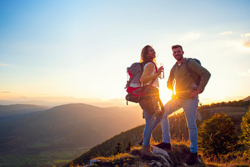 Young Couple Hiking On The Peak of Mountain drinking water