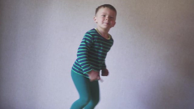 Happy fany boy child jumping on bed in bedroom. Childhood concept.