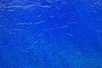 Blue old painted wall with broken plaster. Rough background imitating sea water, underwater world.