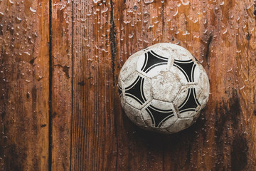 Vertical shot of an old soccer ball on rustic wooden table