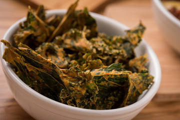 Kale Chips with Chili on a wood rustic table close up