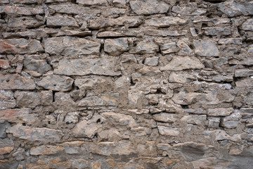 Stone Wall Texture Background with asymmetrical stones stacked together to form a vintage wall