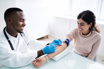 Doctor Injecting Patient With Syringe To Collect Blood