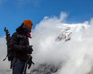 climber on the summit, looking at peak