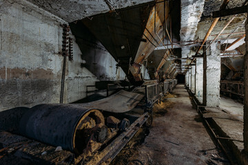 Fototapeta na wymiar Abandoned cement and concrete factory. Old conveyor and rusty hoppers