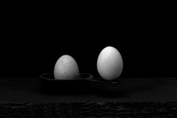 Unequal balance, risk, danger concept or metaphor using eggs and a cast iron skillet