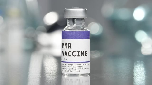 MMR measles, mumps, and rubella vaccine vial in medical lab slowly rotating.