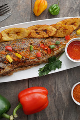 Grilled fish curry with plantain and salad. African national dish. Nigerian fish curry. Healthy lifestyle meal. Vegetarian food
