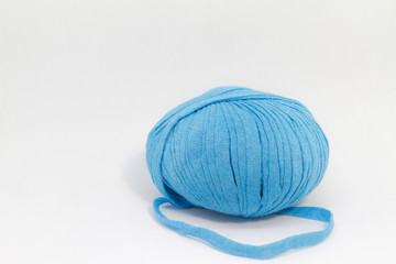 Blue wool ball for knitting on white background with free space at right