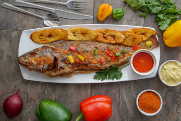 Grilled fish curry with plantain and salad. African national dish. Nigerian fish curry. Healthy lifestyle meal. Vegetarian food