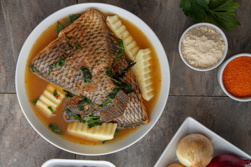 Grilled fish curry with plantain and salad. African national dish. Nigerian fish curry. Healthy lifestyle meal. Vegetarian food