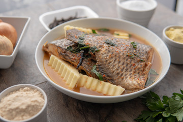 Grilled fish curry with plantain and salad. African national dish. Nigerian fish curry. Healthy lifestyle meal. Vegetarian food