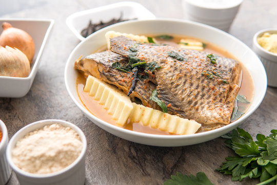Grilled fish curry with plantain and salad. African national dish. Nigerian fish curry. Healthy lifestyle meal. Vegetarian food