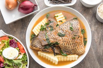 Grilled fish curry with plantain and salad. African national dish. Nigerian fish curry. Healthy lifestyle meal. Vegetarian food