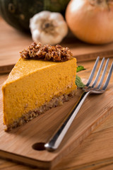Pumpkin Pie with raw granola crust on wood with fork