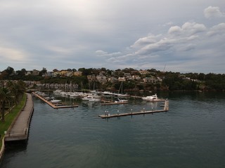 Fototapeta premium Panoramic drone aerial view over Sydney harbour on a cloudy sunset showing the nice colours of the harbour foreshore