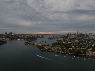 Obraz premium Panoramic drone aerial view over Sydney harbour on a cloudy sunset showing the nice colours of the harbour foreshore