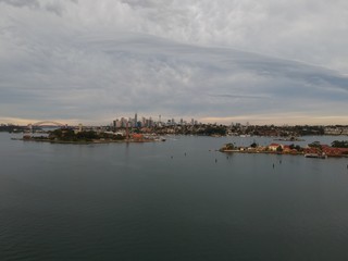 Panoramic drone aerial view over Sydney harbour on a cloudy sunset showing the nice colours of the harbour foreshore