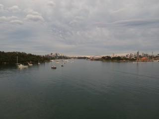 Obraz premium Panoramic drone aerial view over Sydney harbour on a cloudy sunset showing the nice colours of the harbour foreshore