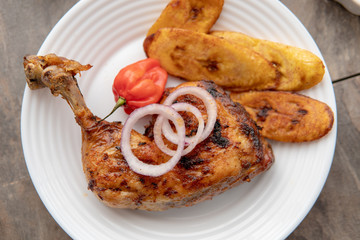African national food dish grilled meat and chicken dish wings home-made Cuisine with plantain with jollof rice. Nigerian Jolofrice. Grilled African fish dish and meal with chilli banana and plantain.