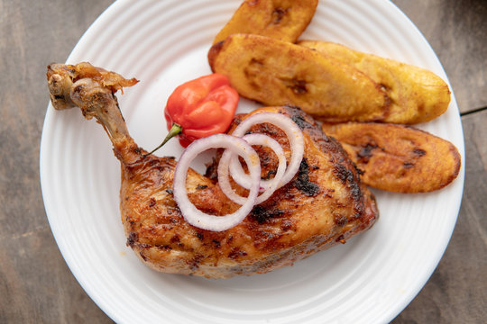 African national food dish grilled meat and chicken dish wings home-made Cuisine with plantain with jollof rice. Nigerian Jolofrice. Grilled African fish dish and meal with chilli banana and plantain.