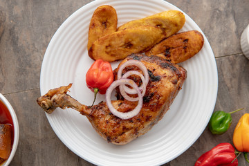 African national food dish grilled meat and chicken dish wings home-made Cuisine with plantain with jollof rice. Nigerian Jolofrice. Grilled African fish dish and meal with chilli banana and plantain.