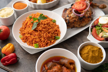 African national food dish grilled meat and chicken dish wings home-made Cuisine with plantain with jollof rice. Nigerian Jolofrice. Grilled African fish dish and meal with chilli banana and plantain. © Rahim