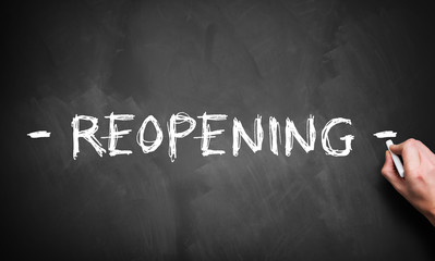 hand writing REOPENING on blackboard