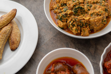 African national food dish grilled meat and chicken dish wings home-made Cuisine with plantain with jollof rice. Nigerian Jolofrice. Grilled African fish dish and meal with chilli banana and plantain.