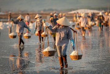 Fototapeta na wymiar Salt and Silhoutte of salt farmer on salt field Hon Khoi, Nha Trang, Khanh Hoa, Vietnam.