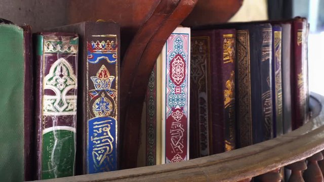 Row of Muslim Quran Islamic holy books lay in mosque for religious studies