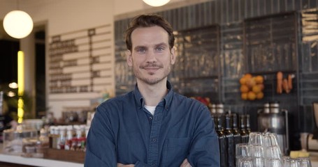 Portrait of proud small business owner in cafe restaurant looking to camera