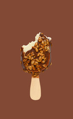 chocolate outer popsicle with melon seeds with some bites on brown background