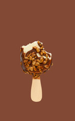 half eaten chocolate outer popsicle with melon seeds on brown background