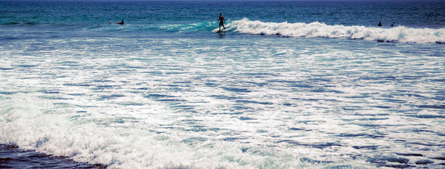 surfer riding waves in Bali Indonesia water sport lessons waves in ocean