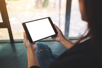 Mockup image of businesswoman holding black tablet pc with blank white screen in the office